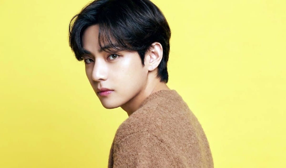 Person with dark hair against yellow background