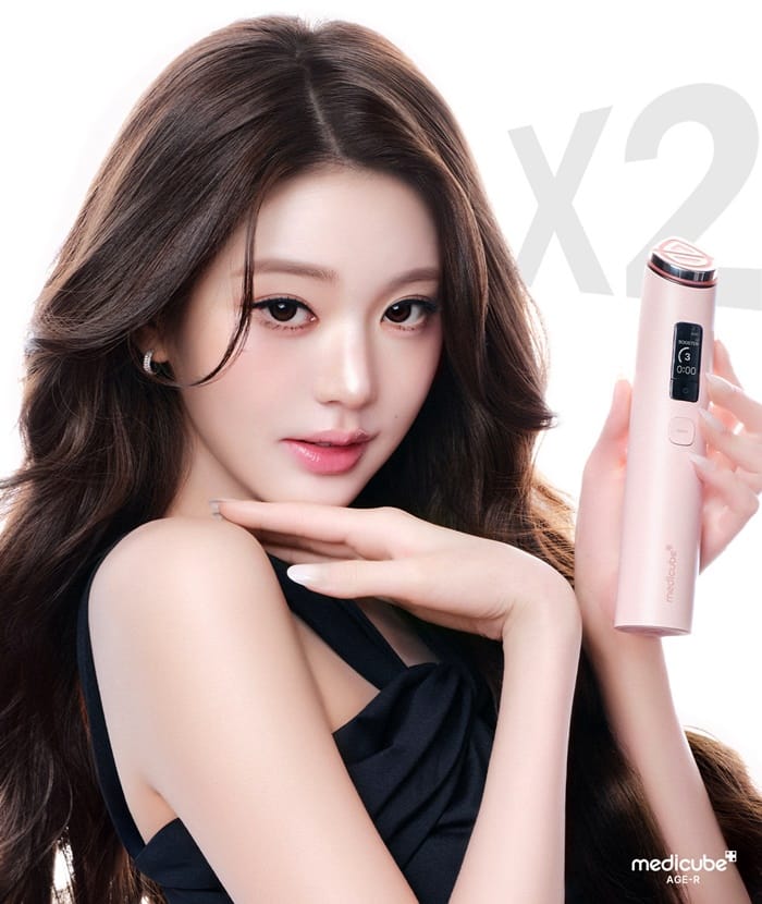 Jang Wonyoung posing with Medicube AGE-R Booster Pro X2 for her iconic 2026 airport glow