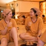 A tourist relaxing in a Korean Jjimjilbang while wearing the iconic sheep-head towel.