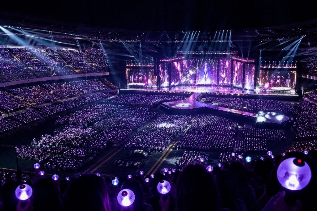 A grand stadium concert of the Best K-pop boy groups 2026 with vibrant stage lighting.