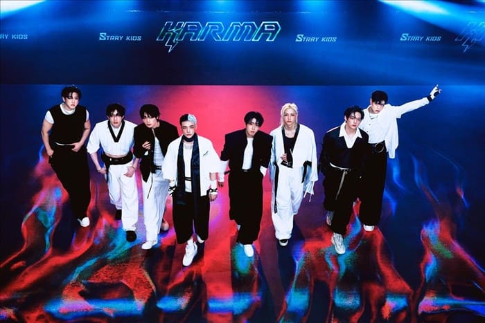 Stray Kids performing on stage during their global world tour in front of a cheering crowd of STAY fans.