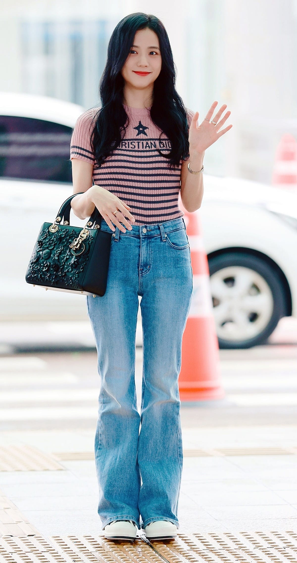 Best dressed female K-pop idols in 2026 featuring Jisoo in a casual off-duty fashion look with jeans, a striped top, and a black handbag.